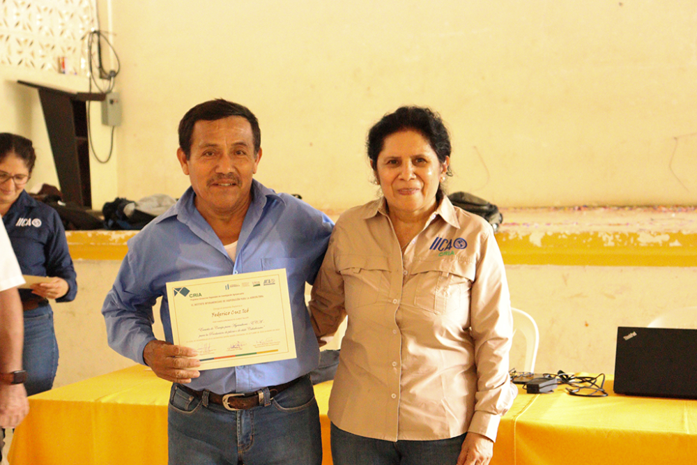 Federico Cuz recibiendo diploma entregado por Inga. María Febres, por haber finalizado la fase de capacitación.