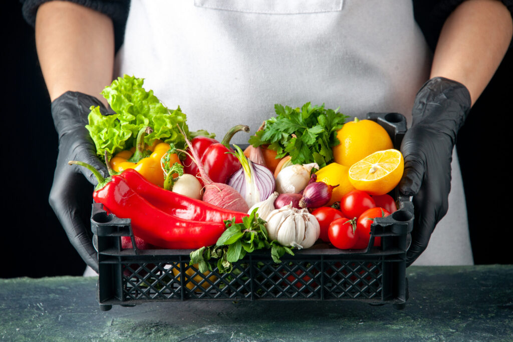 front-view-female-cook-holding-basket-with-fresh-vegetables-on-dark-food-cooking-color-salad-kitchen-cuisine-scaled