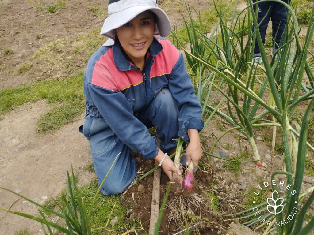 Imagen de una joven cosechando cebollas en un huerto, símbolo del liderazgo rural y la agricultura sostenible. Ideal para contenidos sobre desarrollo agrícola, seguridad alimentaria y empoderamiento comunitario en América Latina.