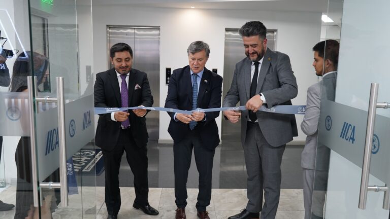 3 personas cortando una cinta en una puerta como parte de la inauguración de las nuevas oficinas del IICA Ecuador