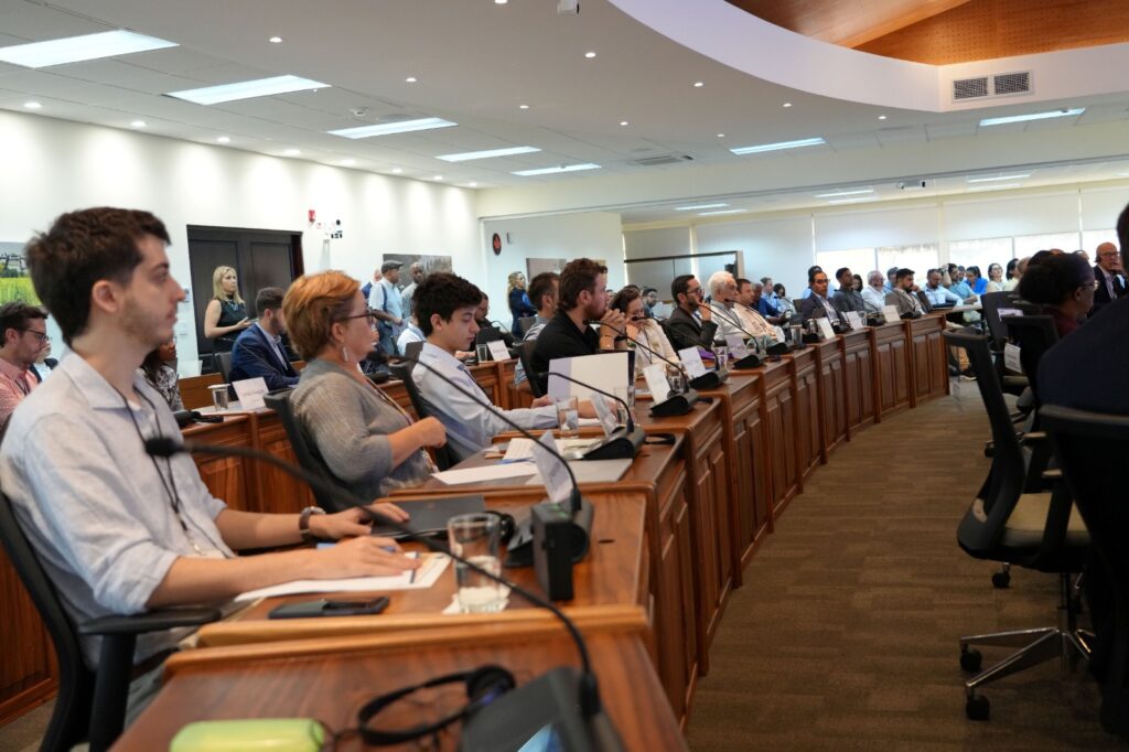Sala de conferencias moderna con profesionales participando en reunión empresarial. Ambiente iluminado, disposición en forma de U y mobiliario elegante reflejan la seriedad y el enfoque colaborativo del evento. Ideal para contenidos sobre seminarios, capacitaciones, encuentros corporativos y conferencias institucionales.