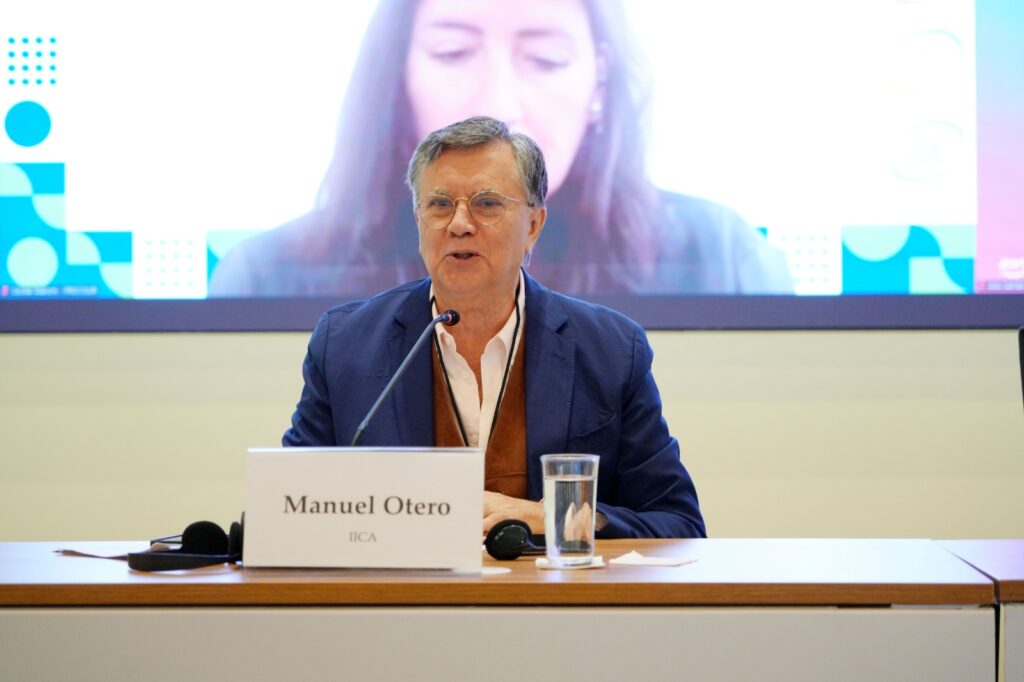 Manuel Otero, Director General del IICA, participa en conferencia internacional sobre agricultura digital. La imagen lo muestra en un entorno formal, con micrófono y logotipo institucional, destacando su liderazgo en la transformación del agro en las Américas. Ideal para contenidos sobre cooperación hemisférica, innovación agrícola y eventos del IICA.